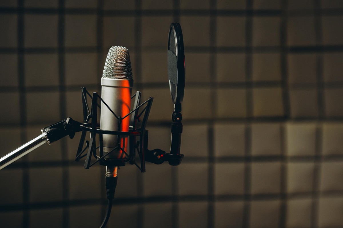 Person recording voiceover at microphone
