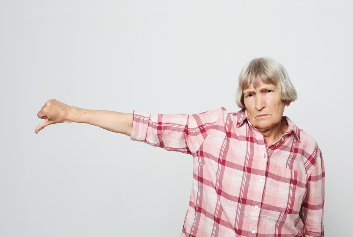 Stern older woman pointing finger disapprovingly